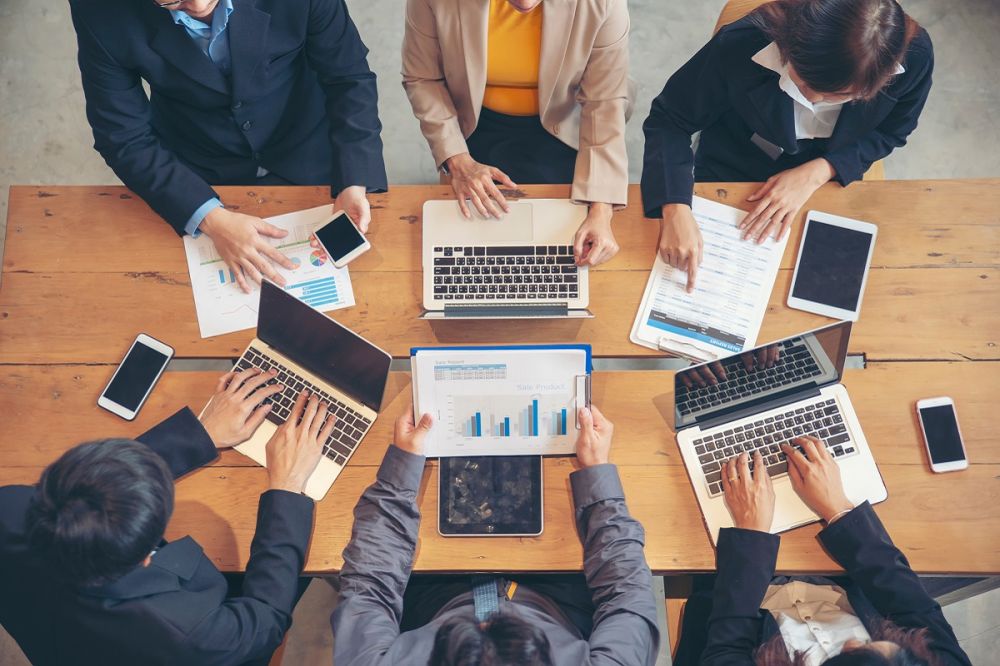 Groupe de personnes travaillant avec un ordinateur portable, des téléphones et des tablettes